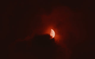 A red full moon with clouds.