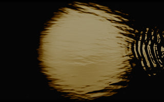 A full moon reflected in water.