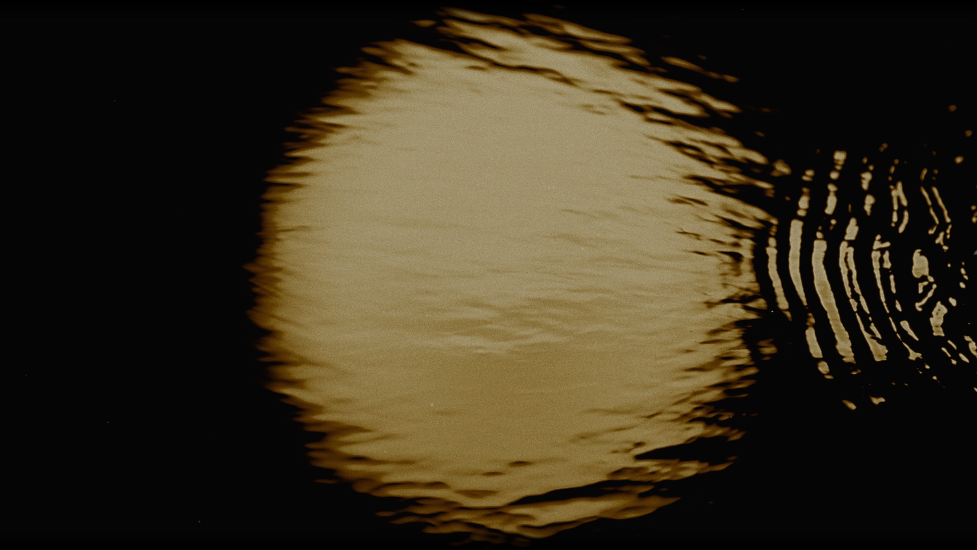 A full moon reflected in water.