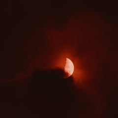 A red full moon with clouds.